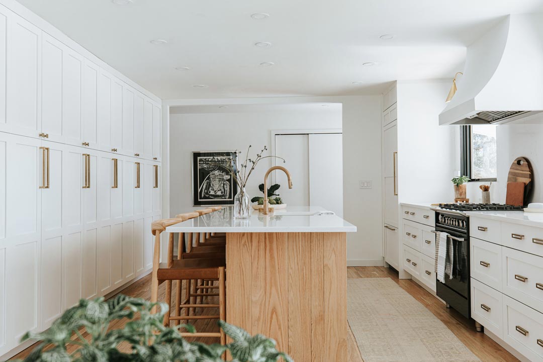 Mid Mod Farmhouse Kitchen Remodel with White Shaker Cabinets and Brass Hardware and Vintage Black Range in Denver Colorado Wood Beam Ceiling by J. Reiko Design + Co 
