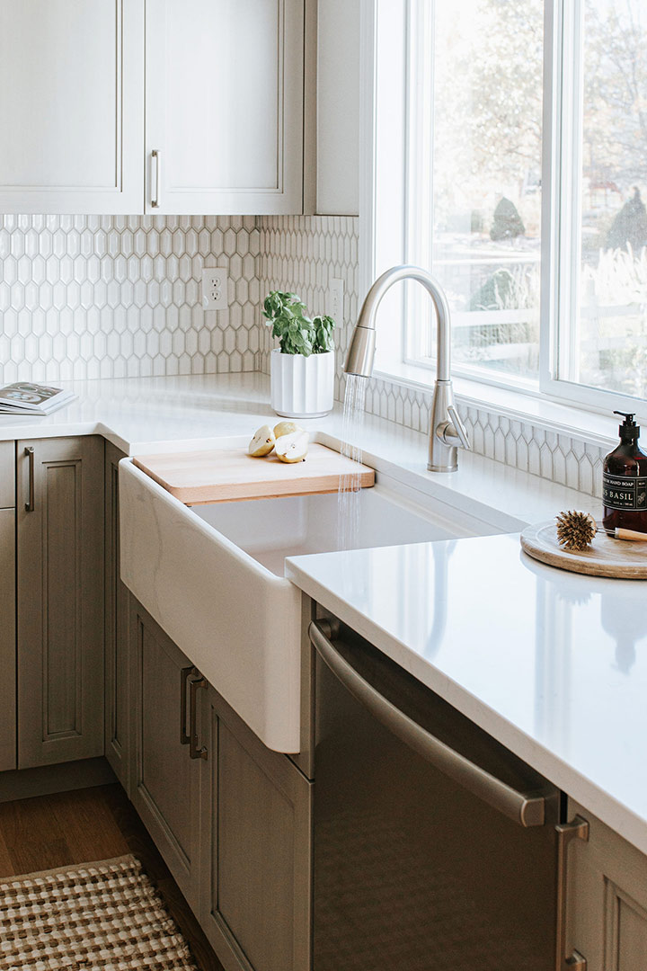 Workstation, farmhouse sink with a cutting board nestled in provides a functional space for this broomfield kitchen remodel.