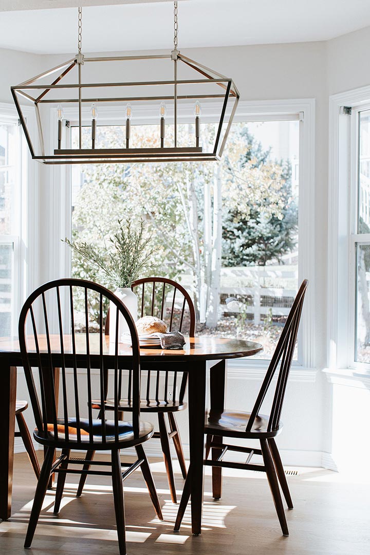 Jenny Murphy of J. Reiko Design + Co carefully selects a caged dining light to compliment the transitional design of the dining room.