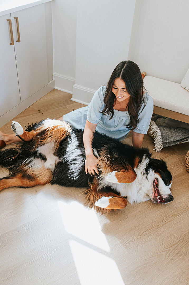 Jenny Murphy, the interior designer of J. Reiko Design + Co plays with her Bernese Mountain dog on the floor of her studio