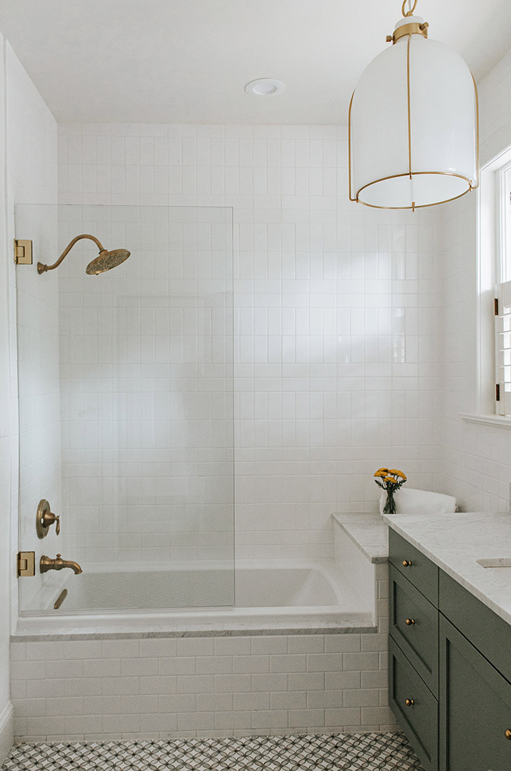 Traditional feeling tub and shower custom designed by Jenny Murphy of  J. Reiko Design + Co. with marble mosaic floor tile and brass finishes. 