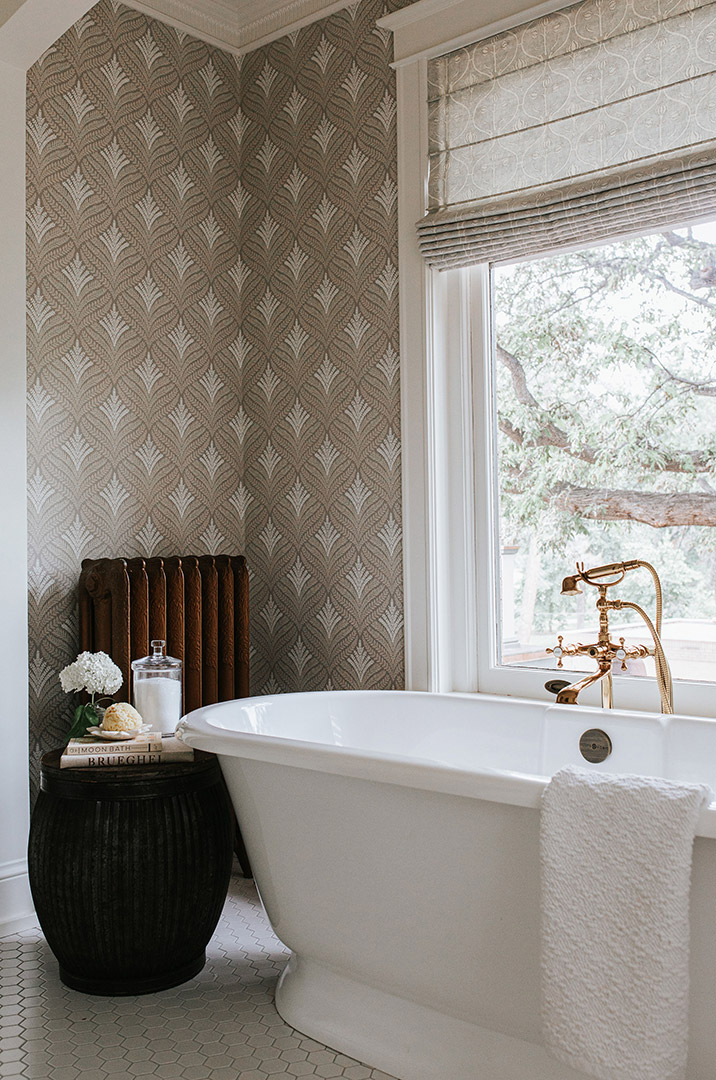 Hexagon mosaic floors accent the traditional styling chosen by Jenny Murphy for the wallpaper and the tub. 