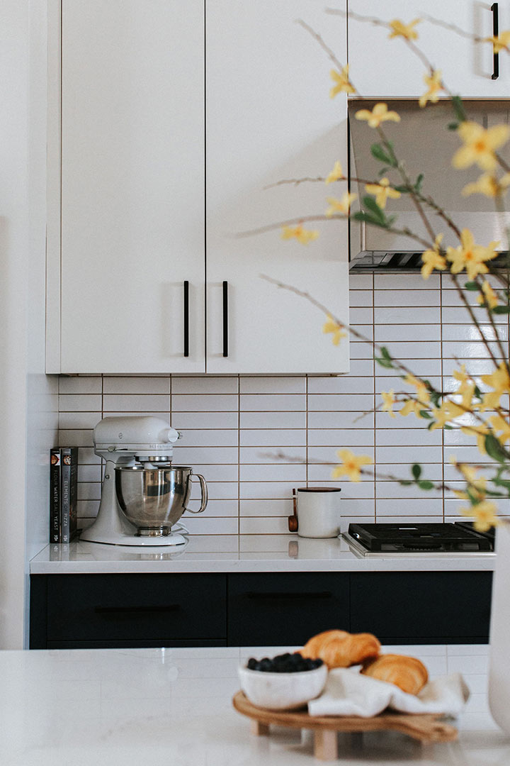 Clean lines in the Straight Stacked Subway Tile Backsplash and the matte black hardware make this Denver home's modern kitchen renovation a complete success.