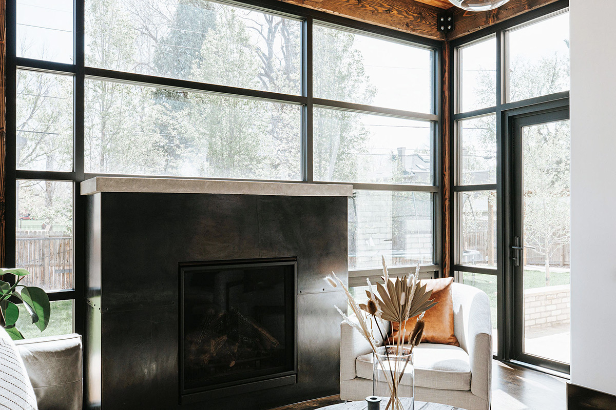 Modern Industrial Room with Full Window Wall, Steel Fireplace and Concrete Mantle with Door to Backyard and Leather Pillow
