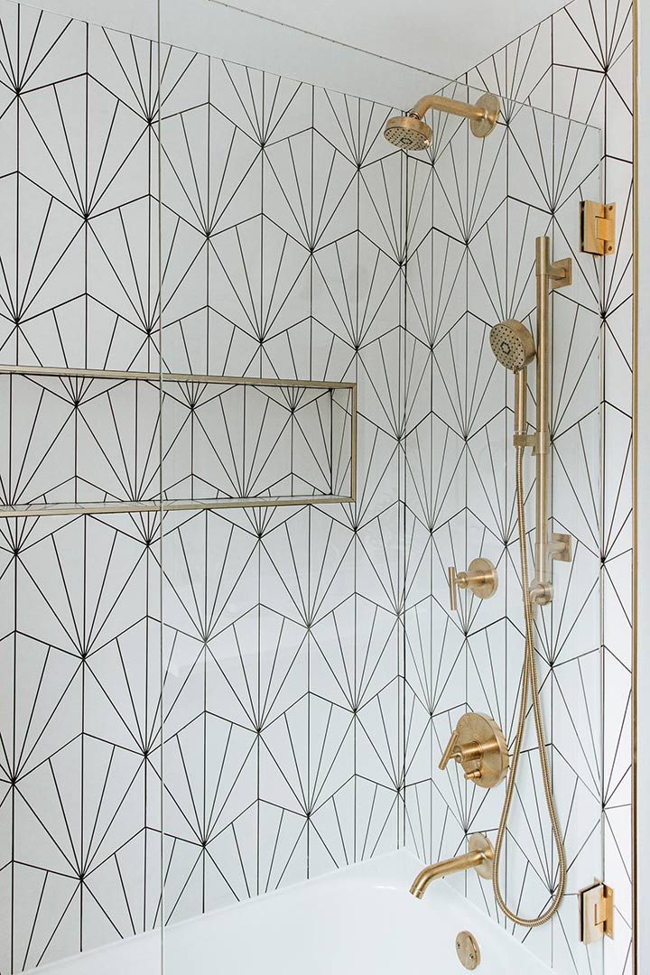 A dreamy bright shower with a modern pivoting glass shower shield and beautiful brass hardware makes anyone want to take a mid-day shower getaway.