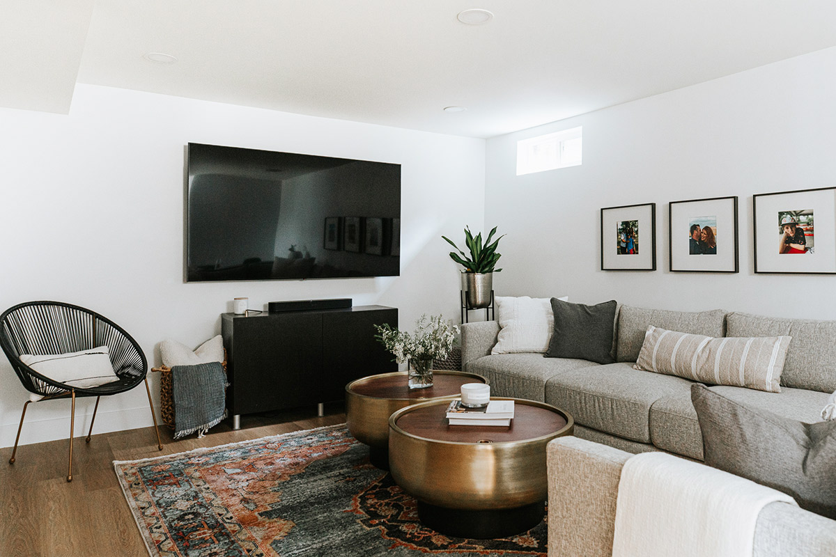 A Light Gray Modern Sectional is a staple of the comforting vibe of a modern living room in a basemnet remodel.