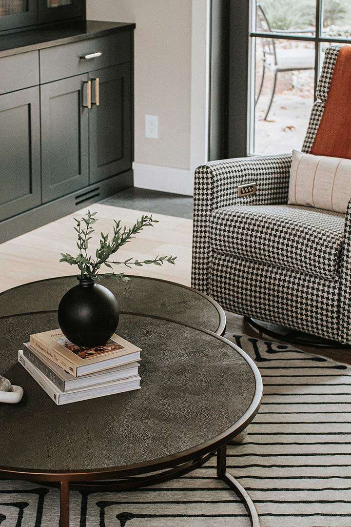 A custom designed houndstooth rocker next to a circular hammered brass nesting table in Windsor Colorado