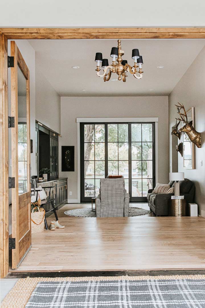 Wood headers and black hardware frame the entryway of a modern farmhouse home in Windsor Colorado