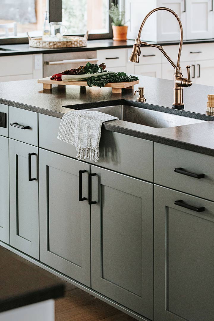 Workstation sink with a beautiful gold faucet in a modern farmhouse kitchen