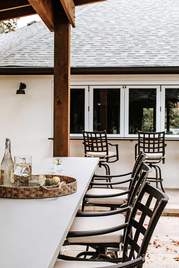 Modern farmhouse chairs frame two outdoor bars on this Ptarmigan Country Club property