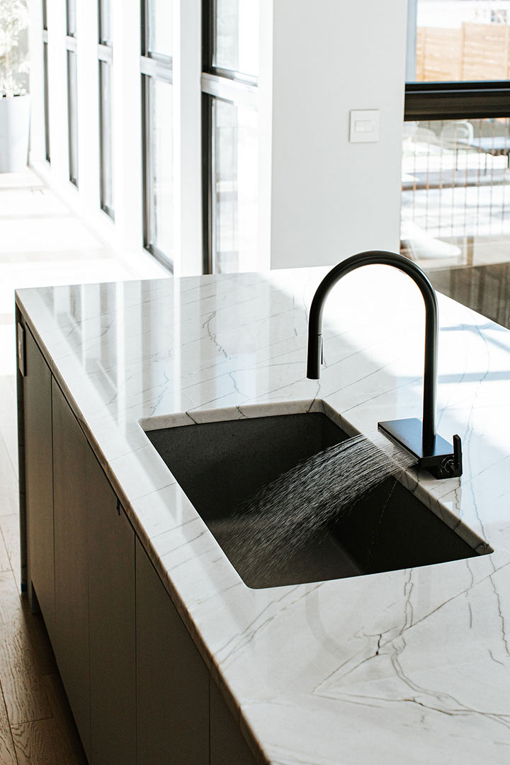 Water shoots our of the veggie wash spray black Hansgrohe Faucet carefully chosen to match the minimalist interior design style of the modern Japandi new build kitchen.