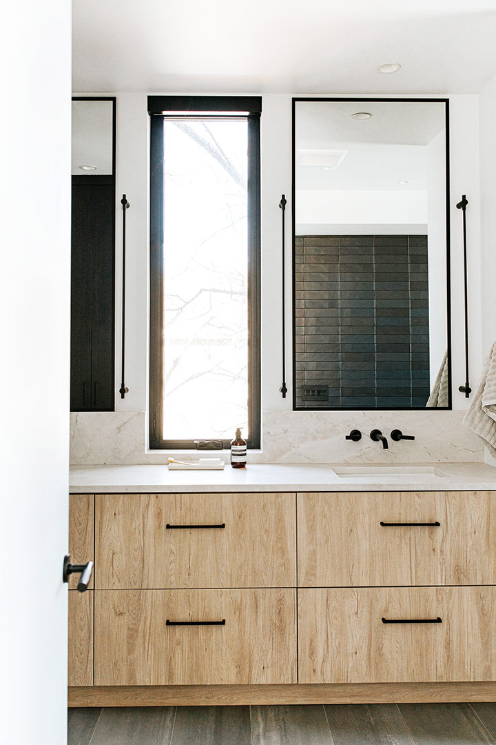 White oak cabinets base Quartzite Countertops with modern black wall mounted faucets and hardware in this Denver new build bathroom design by J. Reiko Design + Co