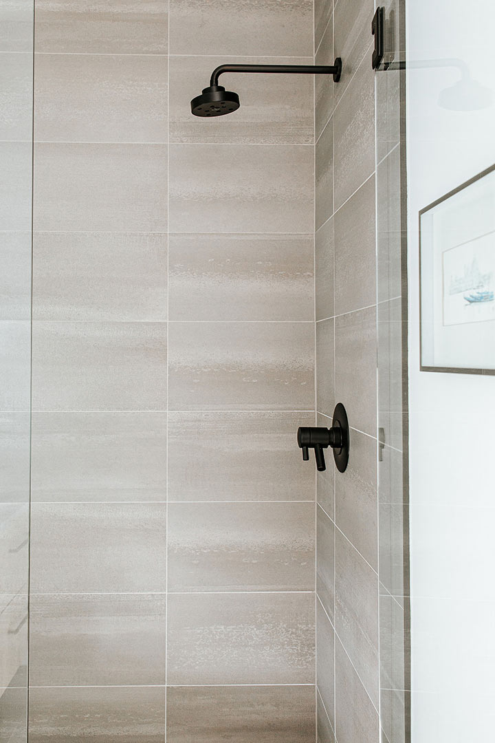 Neutral tile shower with matte black fixtures designed by J. Reiko Design + Co