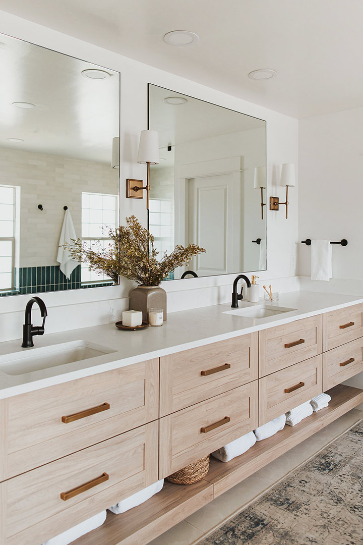 White oak bathroom cabinets with quartz countertops paired with black fixtures and brass hardware make this modern classic bathroom renovation in Denver Colorado feel complete
