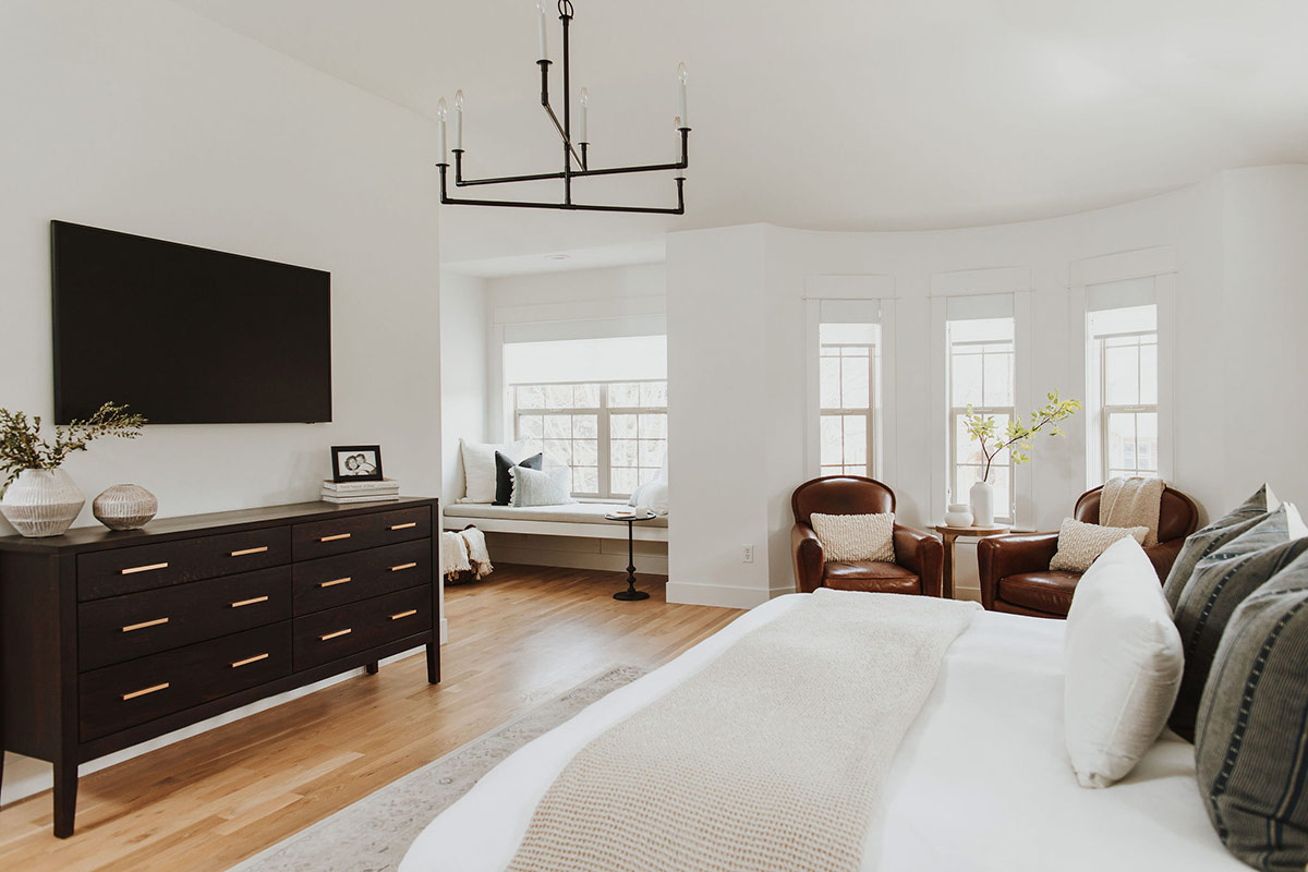 Modern minimalist bedroom design with a aged iron chandelier in this Modern Classic Denver Renovation
