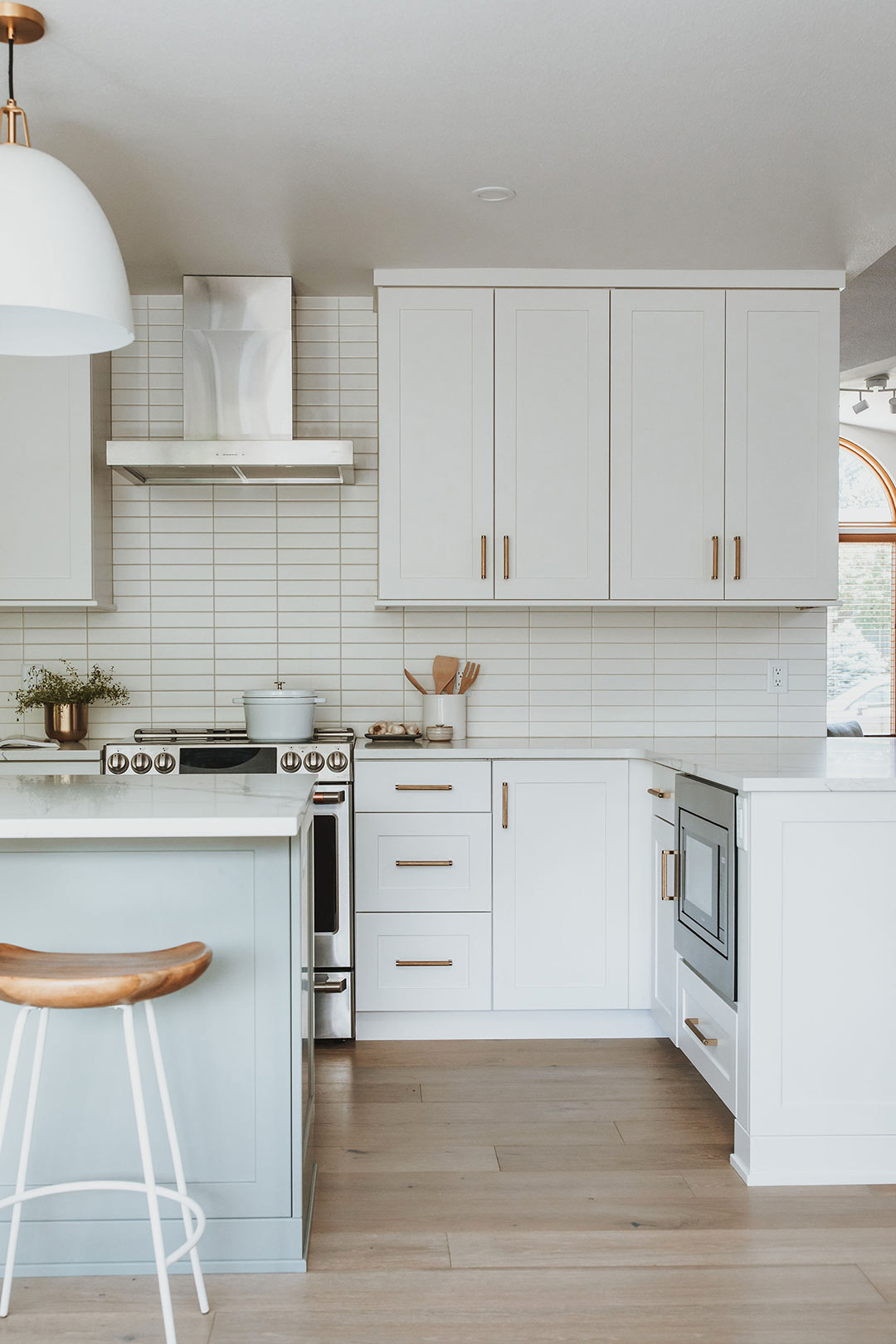Modern kitchen with white shaker cabinets, brass pulls, and modern square stacked subway tile backsplash in Fort Collins Colorado by J. Reiko Design + Co 
