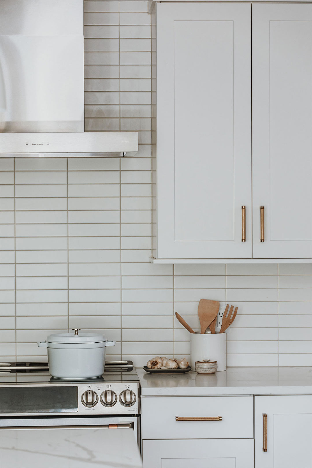 Modern straight stacked white subway tile in a modern minimalist kitchen design by J. Reiko Design + Co