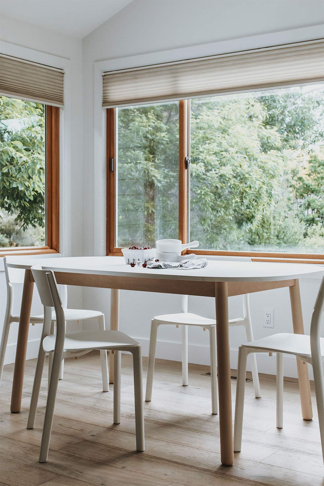  Scandinavian dining table with white modern chairs in a bright dining room designed by J. Reiko Design + Co