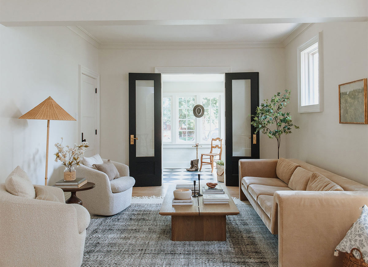 View of the living room showing the boucle side chairs and CB2 Perimeter camel sofa used to create a transitional design for this historic remodel in Denver Colorado