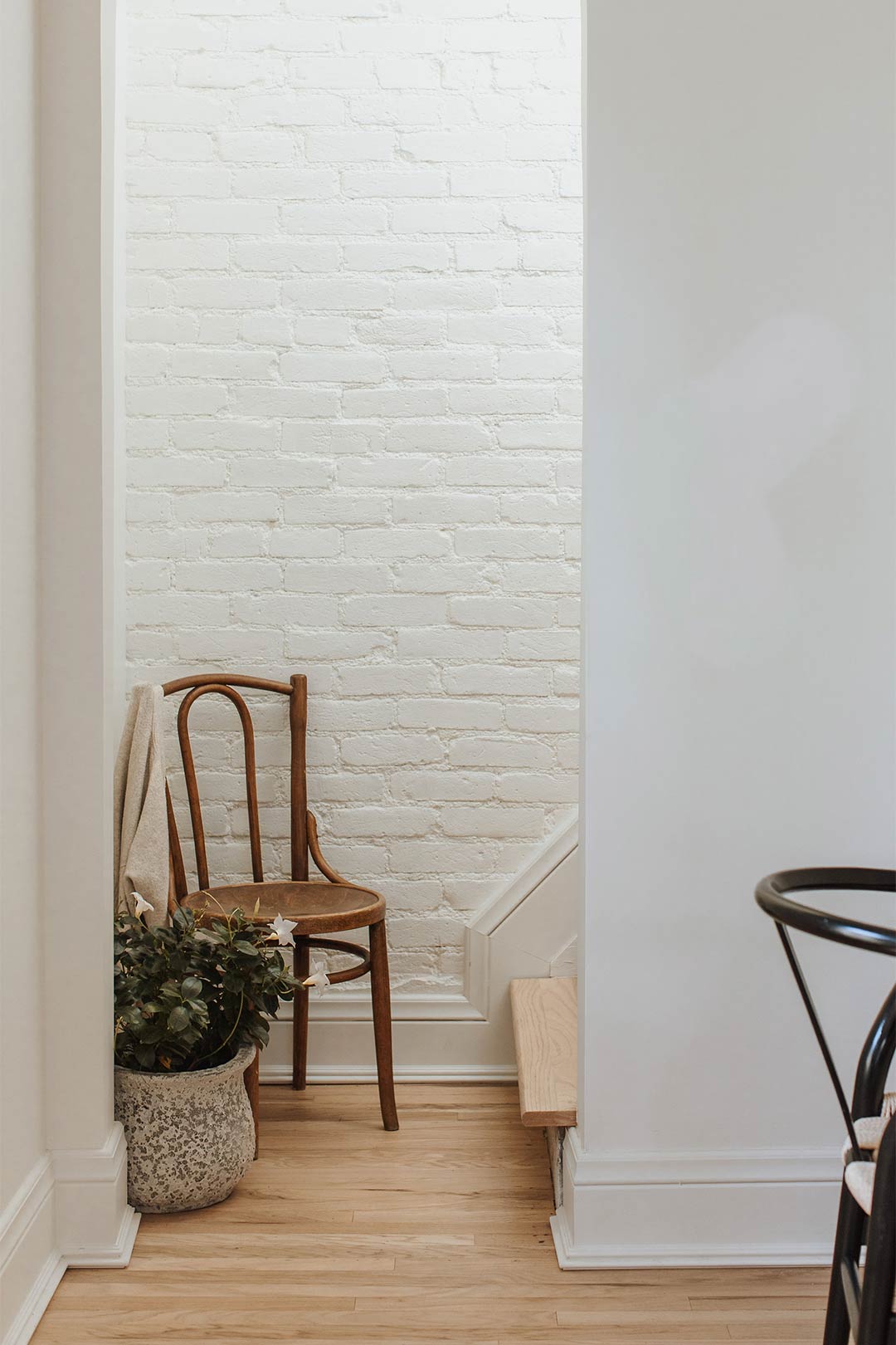 A peek into the upstairs with painted brick and white oak flooring
