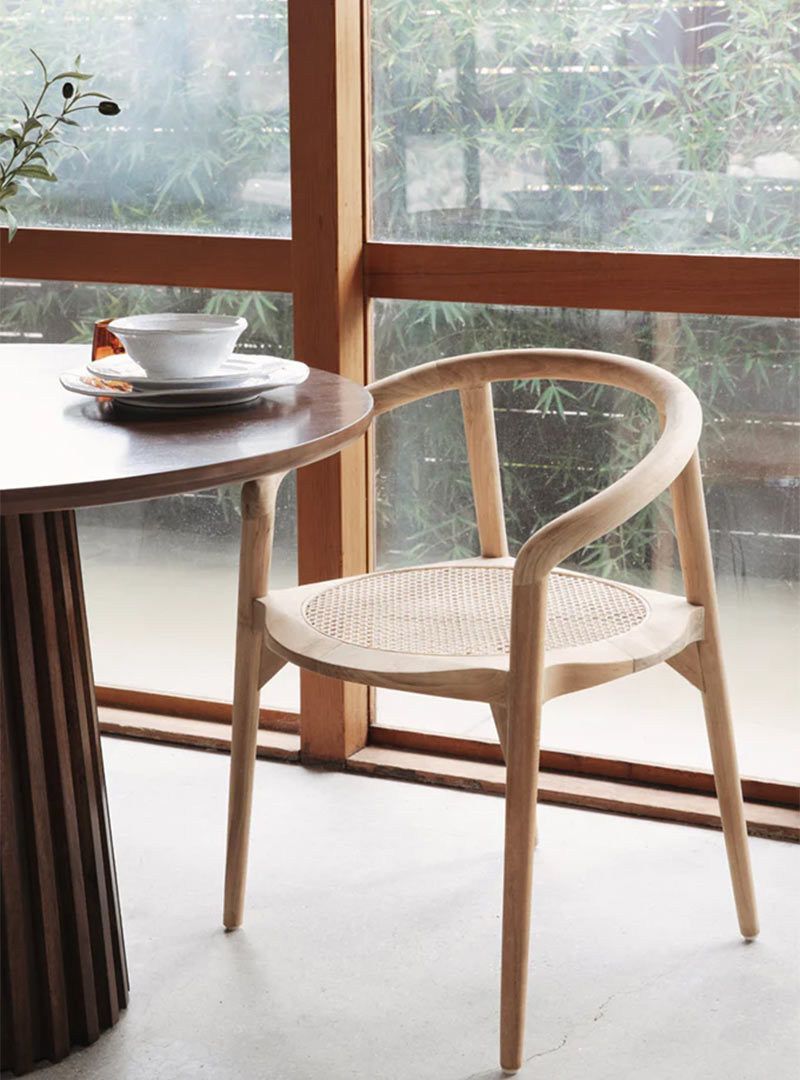 An in use example of the Adalyn Dining Chair from MyCuraHome.com a natural teakwood chair with soft organic curves fitting of the Japandi Style