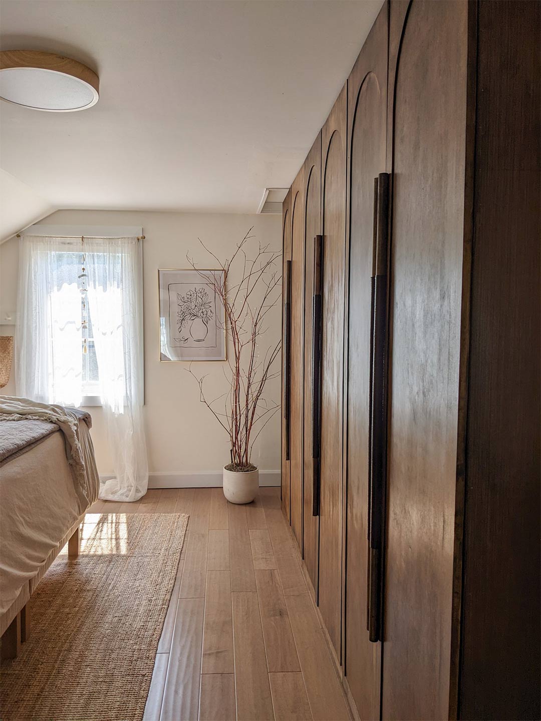 An example of a minimalist wood wardrobe in a soft quiet luxury bedroom design