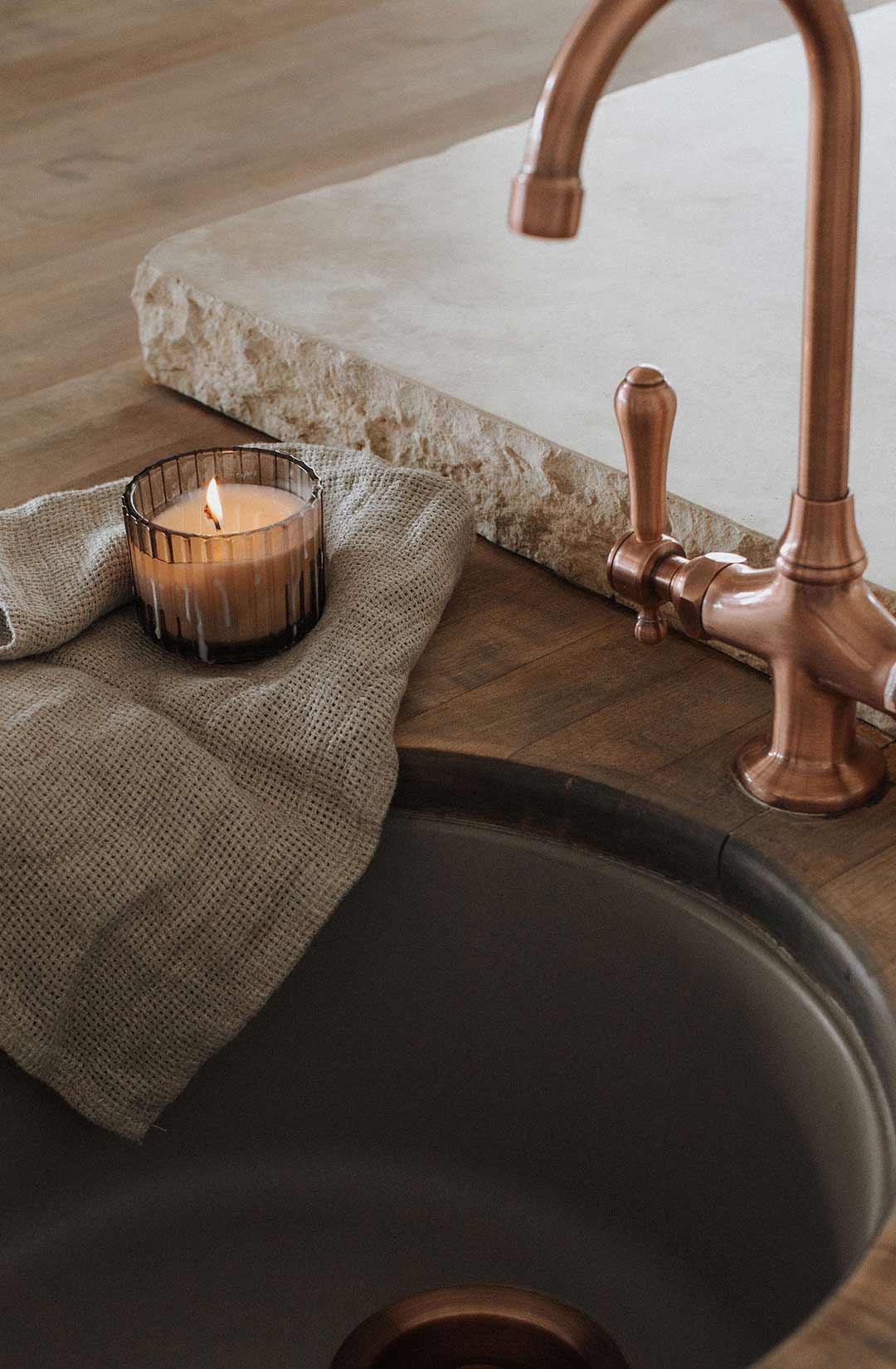 Top down view of the sink in the island of this Mediterranean kitchen that features a Butcher Block Countertop and a Newport Brass Chesterfield Faucets in Copper and 