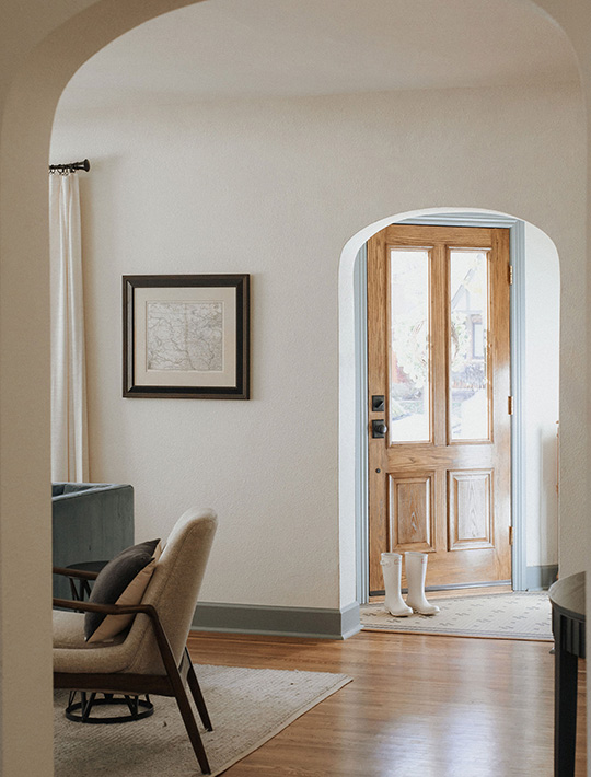 J. Reiko Design + Co. - Open vs. Closed Concept - 11 The entryway and separate closed dining area of a Tudor revival home show the large arched doorway opening that separate each room but are bigger than the traditional layout making the rooms feel slightly more connected than before.