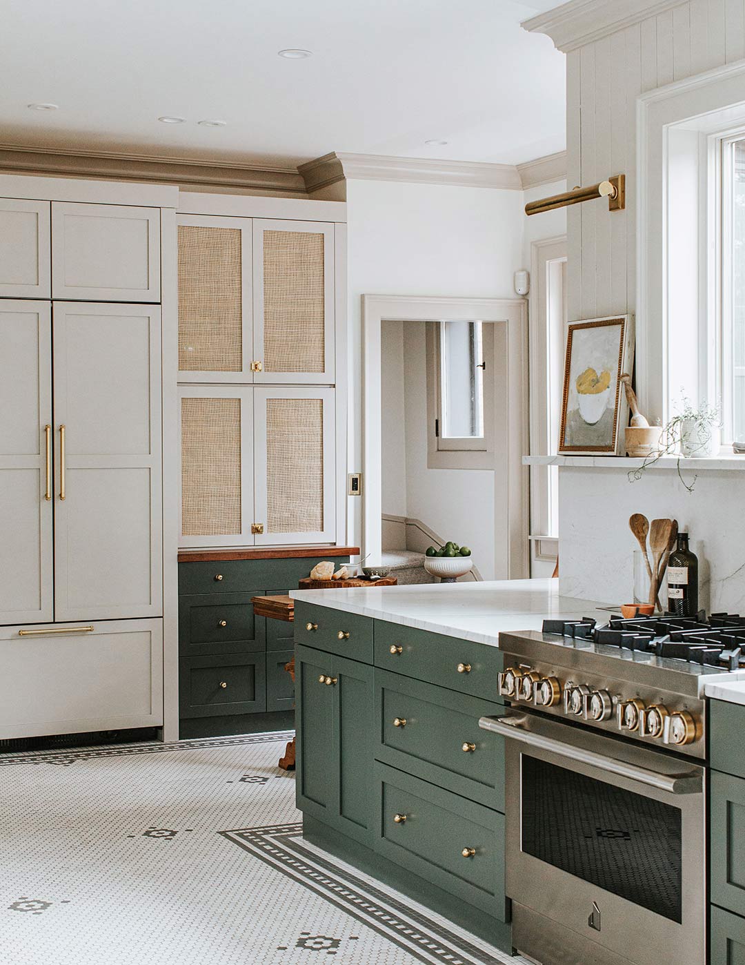 J. Reiko Design + Co. - Selecting Finishes - 12 A historic home remodel's kitchen that showcase a variety a interior design finish materials. Knobs, pulls, light fixtures all in a antique brass with light painted built in kitchen cabinetry and dark hunter green lower cabinetry. Tongue and groove on the walls above the marble backsplash with a shelf mirror the tone and historic feel in the floor covering of a custom mosaic tile.