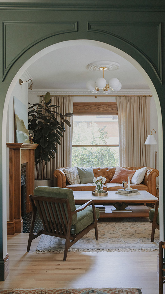 J. Reiko Design + Co. - Selecting Finishes - 4 An arched opening between two rooms in a historic home renovation by J. Reiko Design + Co. The arched frame door casing is painted in a soft hunter green with custom moulding. The wall finish color tones pull into the living room's period furniture to tie the look together.