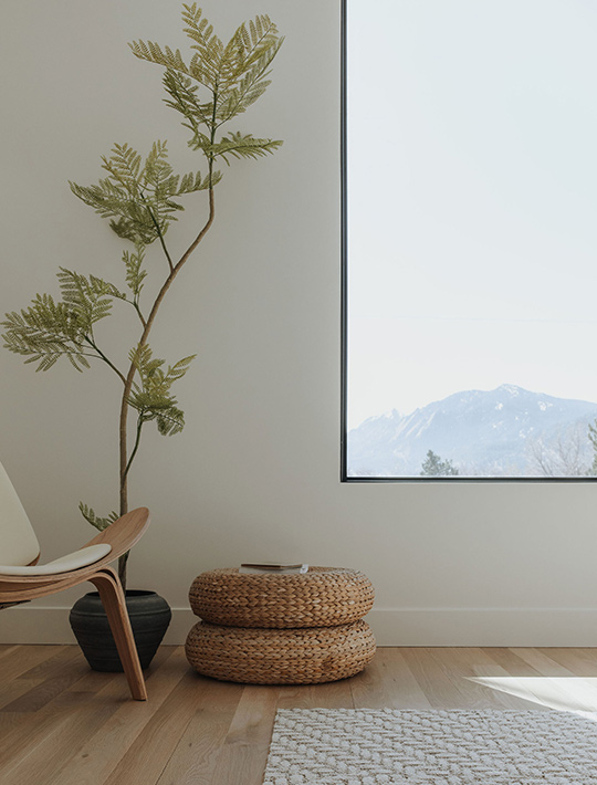 J. Reiko Design + Co. - Asymmetrical Rooms - 13 Reading nook framed by a modern window and a curved lounge chair and woven ottomans for soft visual balance.