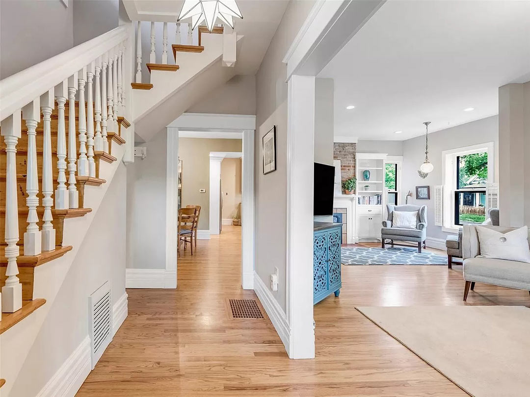 Before staircase and living area showing removed walls, minimal millwork, and disrupted Denver Square floor plan.