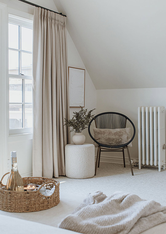 J. Reiko Design + Co. - Modern Colonial Interior Design - 01 Bedroom corner with sculptural chair, linen drapery, and vintage radiator detail.