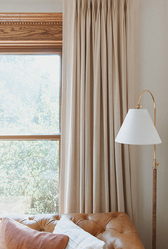 J. Reiko Design + Co. - Modern Colonial Interior Design - 08 Living room detail with caramel leather sofa, linen curtains, and brass floor lamp.