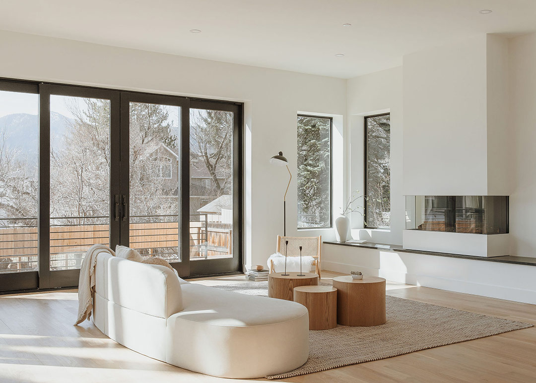 J. Reiko Design + Co. - Quiet Luxury Living Room Ideas - 02 Bright quiet luxury living room featuring sculptural sofa, natural wood tables, large windows, and minimalist styling.