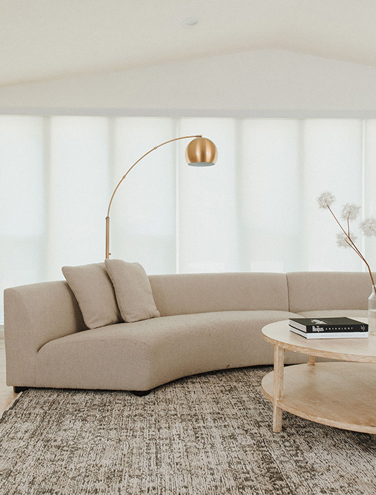 J. Reiko Design + Co. - Quiet Luxury Living Room Ideas - 11 Quiet luxury seating area with curved sectional, brass arc lamp, and round oak coffee table.
